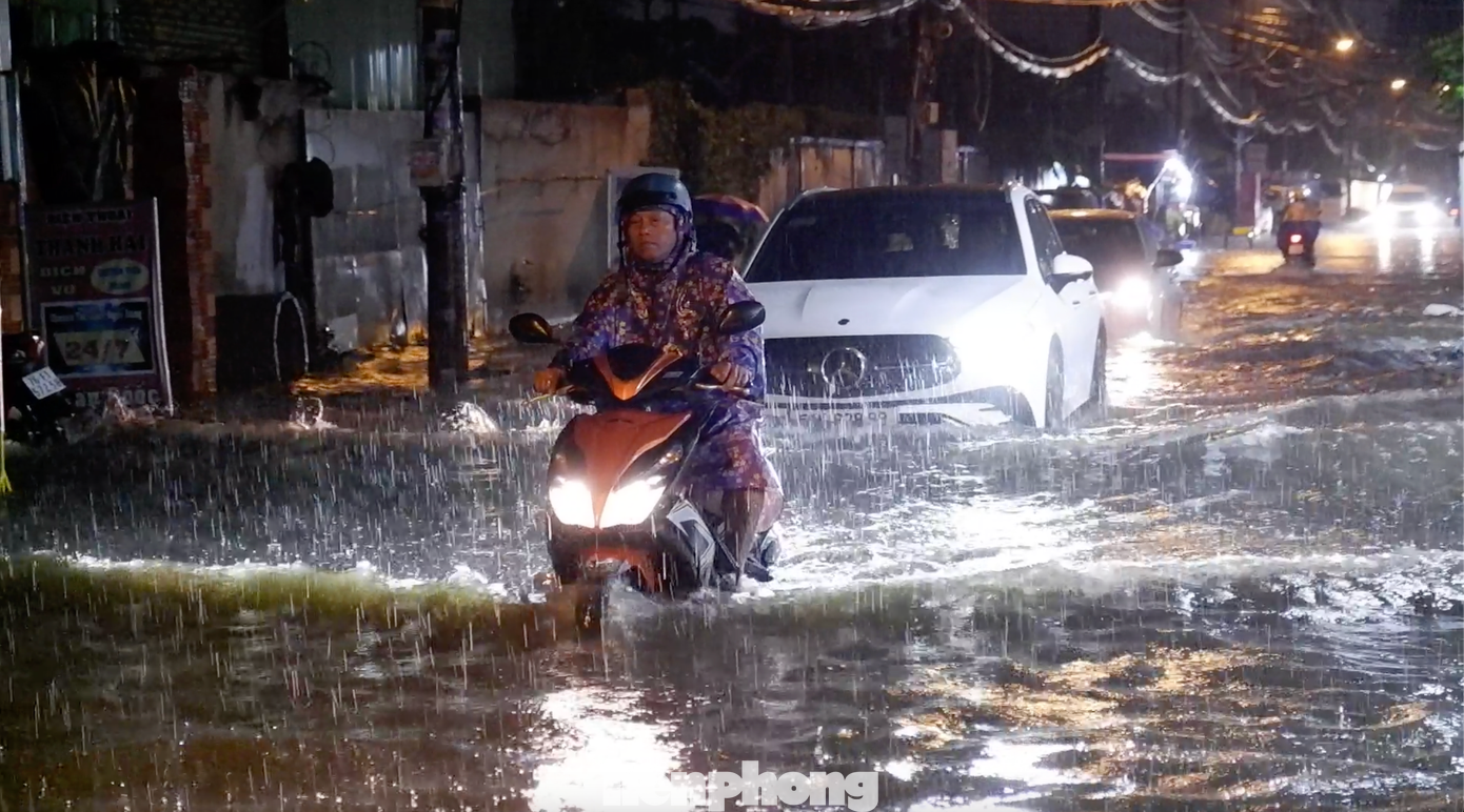 Người và phương tiện bì bõm lội nước trên đường Sinco.