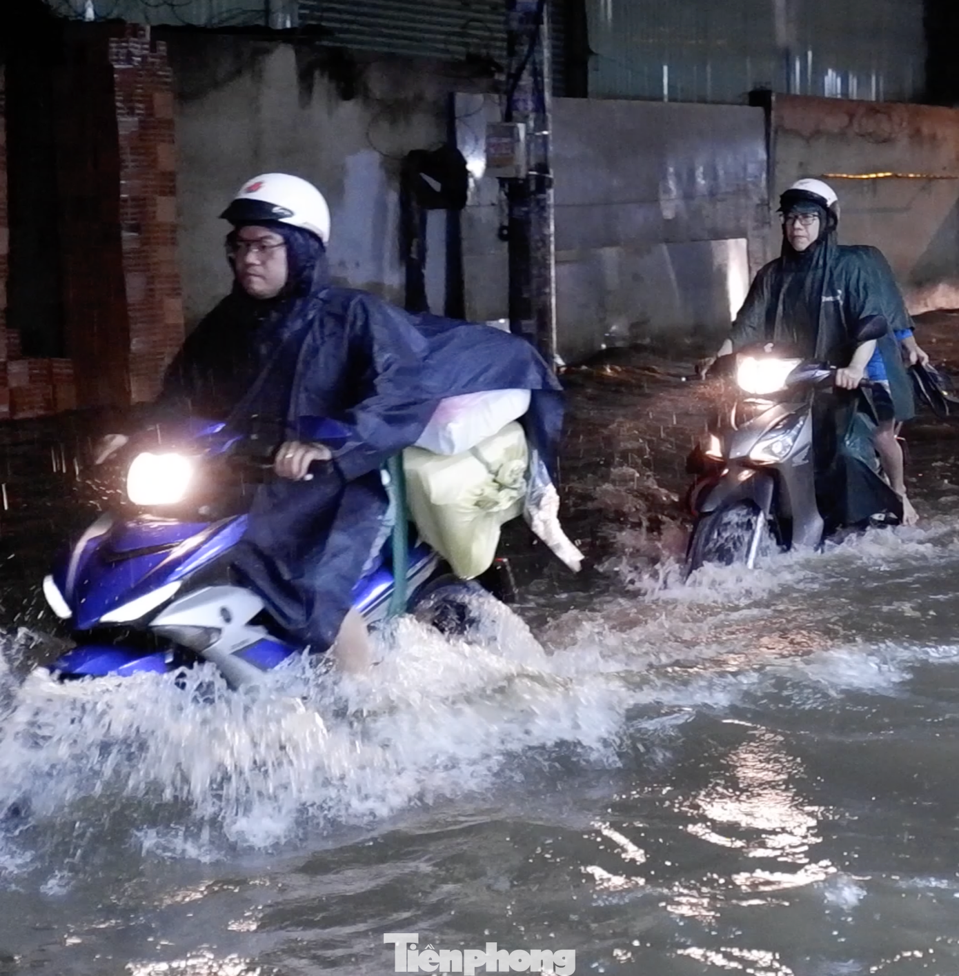 Người và phương tiện di chuyển khó khăn qua điểm ngập úng.