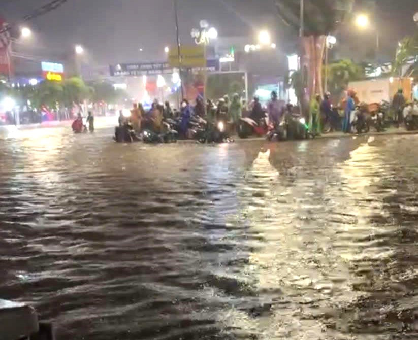 Đường Hùng Vương giao với đường Võ Văn Tần ngập sâu, nhiều người dân phải đứng chờ nước rút