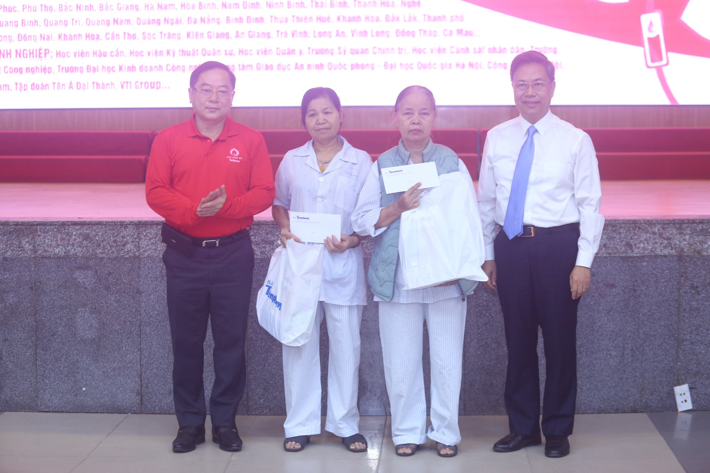 Nhà báo Lê Xuân Sơn – Tổng Biên tập Báo Tiền Phong và PGS.TS Nguyễn Hà Thanh – Viện trưởng Viện Huyết học - Truyền máu Trung ương tặng quà cho hai bệnh nhân. Ảnh: Duy Phạm