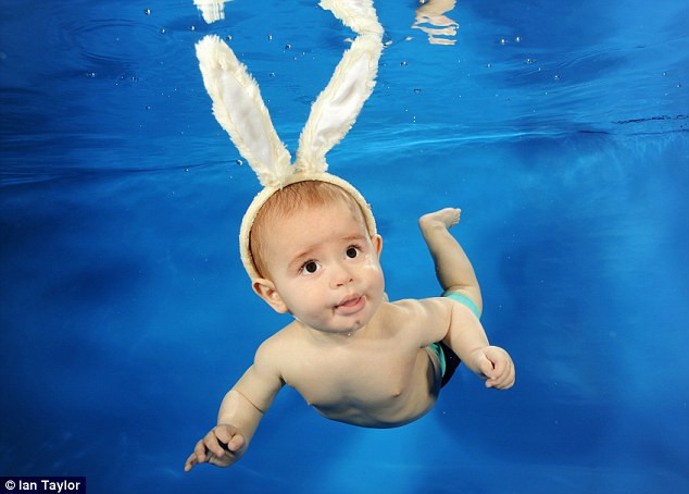 Bé Taghdissian, 8 tháng tuổi thoải mái bơi trong bể nước với hai tai thỏ trên đầu . Bé Taghdissian, 8 tháng tuổi thoải mái bơi trong bể nước với hai tai thỏ trên đầu