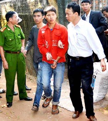 Hoàn bị công an còng tay dẫn giải đi