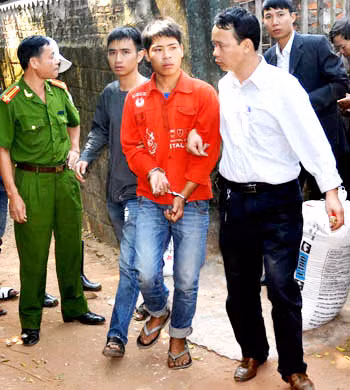 Hoàn bị công an còng tay dẫn giải đi. Hoàn bị công an còng tay dẫn giải đi