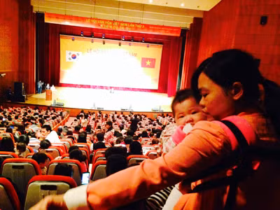 Chị Trần Thị Hường (Hà Nội) lấy chồng Hàn, một mình đưa hai con (đứa bế đứa nằm trong nôi) dự Lễ hội văn hóa Việt Nam tại TP Deajeon, Hàn Quốc, ngày 27/10/2013. Chị nói: “Đến gặp mọi người cho đỡ nhớ nhà”