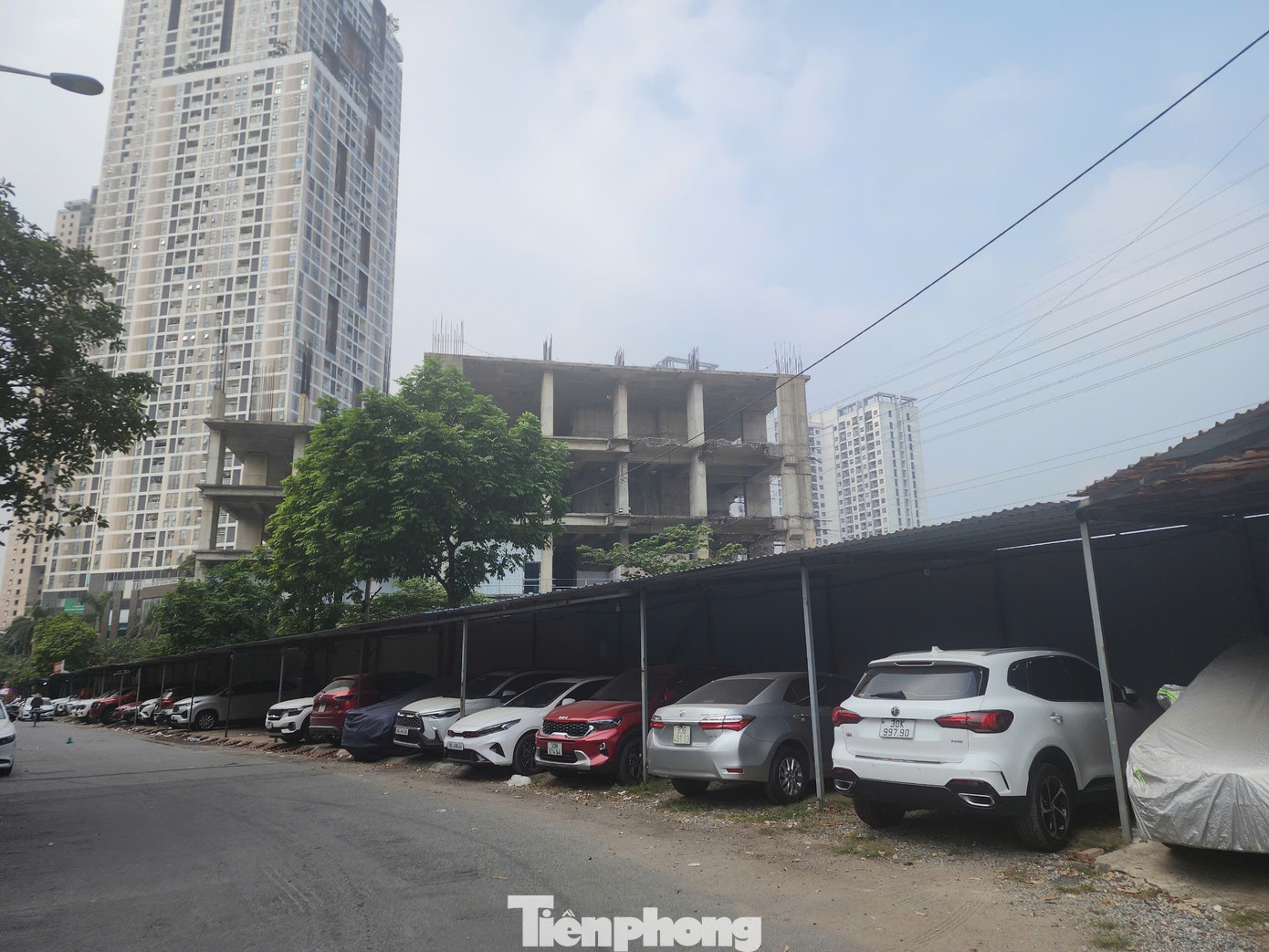 Phía mặt sau của dự án cũng được tận dụng làm chợ tạm và bãi gửi ô tô. Hàng loạt cọc sắt, mái che bằng tôn được dựng lên áp vào hàng rào dự án Usilk City để trông giữ xe ngày đêm