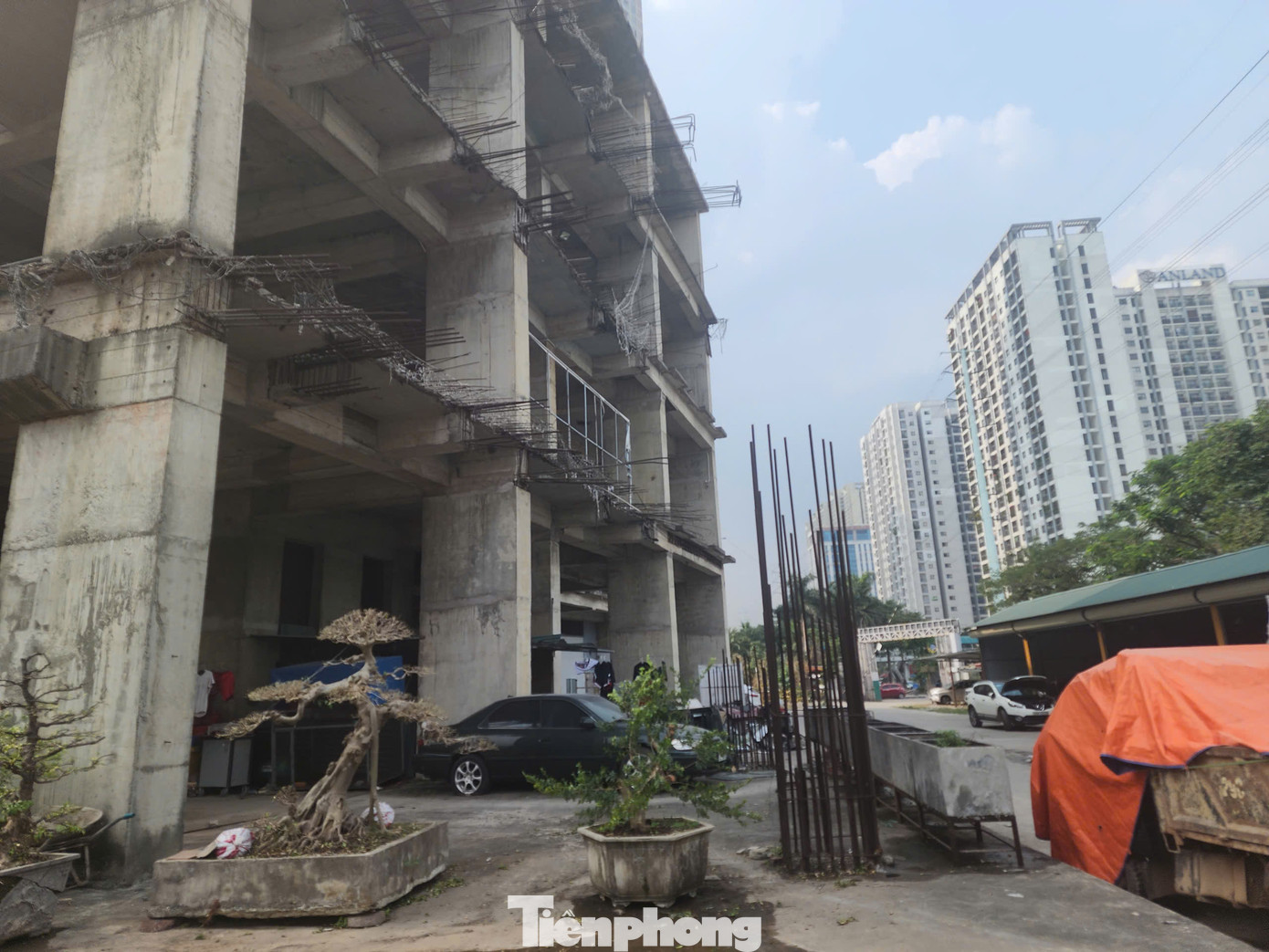 Những cọc sắt dang dở, hoen gỉ thành thành nơi để xe, trưng bày cây cối