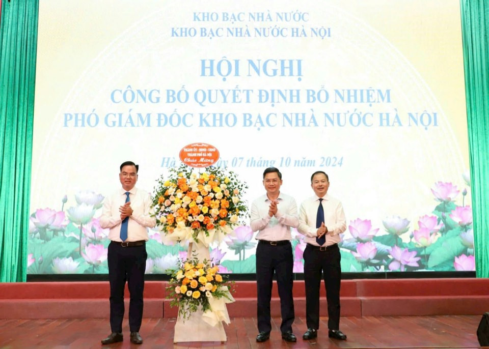Phó Chủ tịch UBND TP. Hà Nội Hà Minh Hải tặng hoa chúc mừng hai tân phó giám đốc Kho bạc Nhà nước Hà Nội. Ảnh: T.G