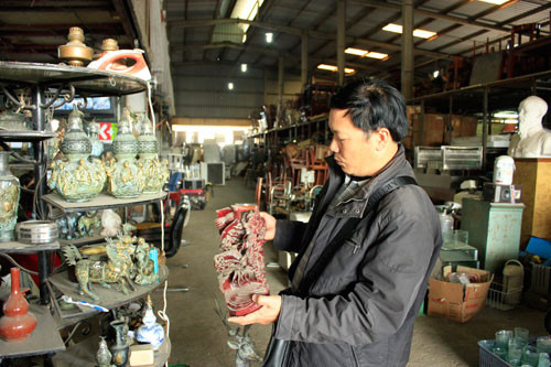 Khách hàng xem tượng tứ linh bằng gỗ tại chợ đồ cũ Thưởng Thưởng