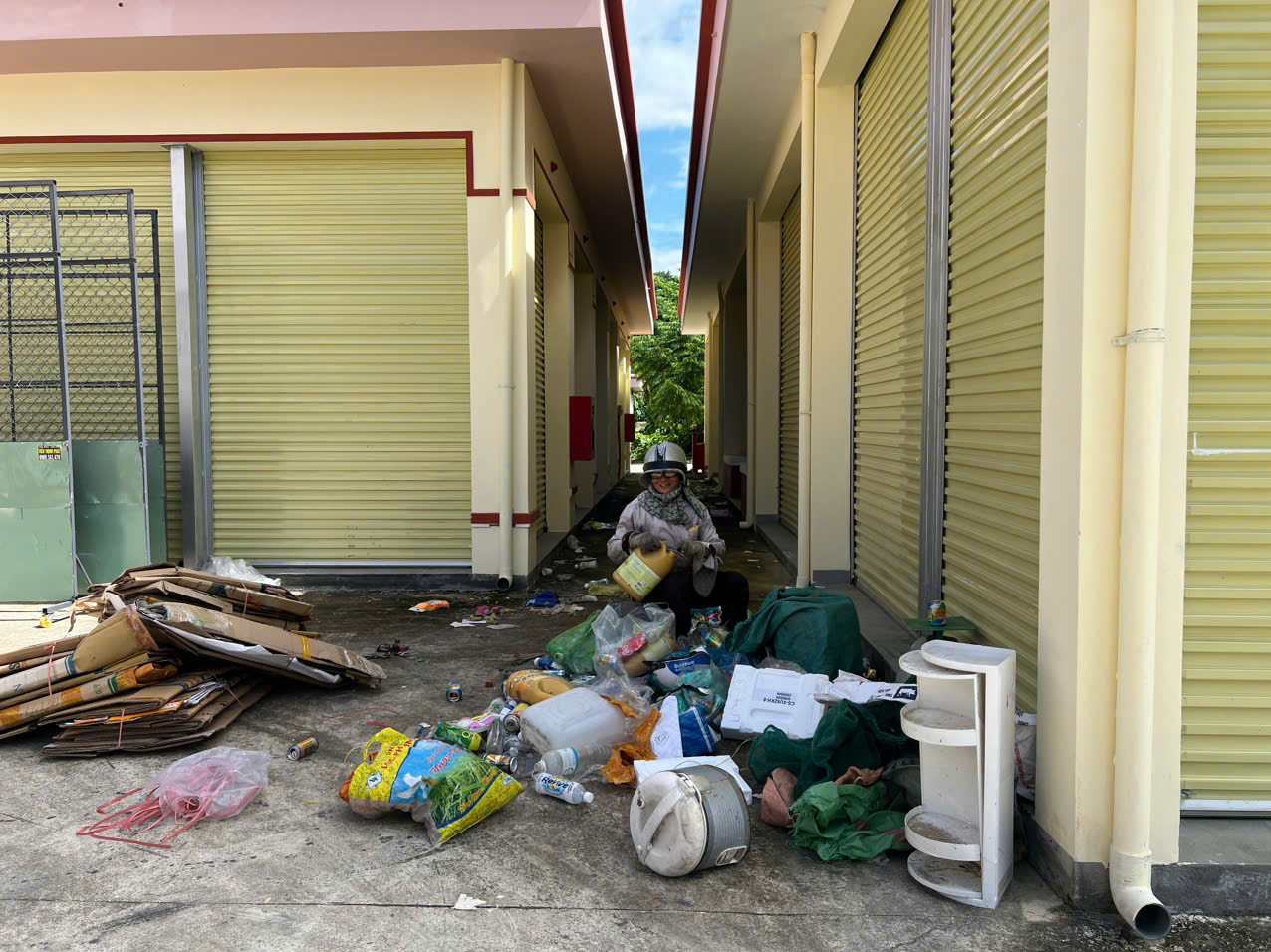 Khuôn viên chợ được tận dụng thành chỗ phơi quần áo (ảnh trên) và tập kết đồ (ảnh dưới).