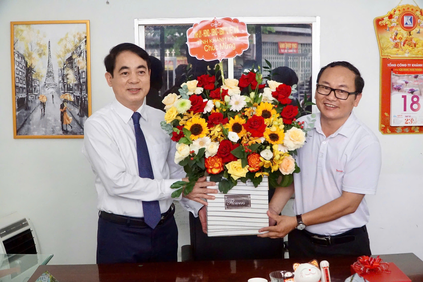 Bí thư Tỉnh ủy Khánh Hòa Nghiêm Xuân Thành (bìa trái) tặng hoa chúc mừng báo Tiền Phong.