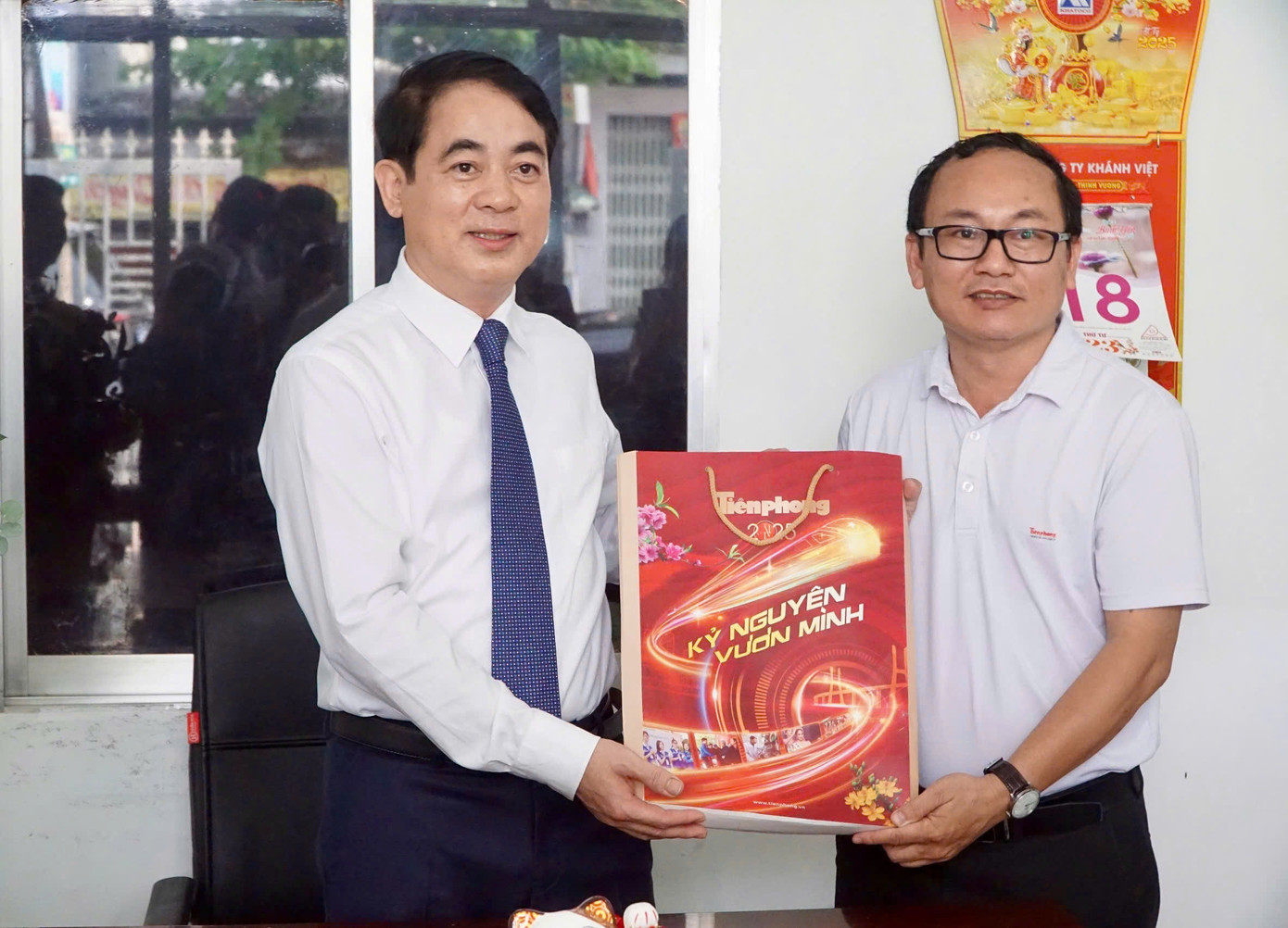 Lãnh đạo Văn phòng đại diện báo Tiền Phong khu vực Tây Nguyên - Nam Trung Bộ gửi tặng ông Nghiêm Xuân Thành (bìa trái) tờ báo Tiền Phong số đặc biệt.