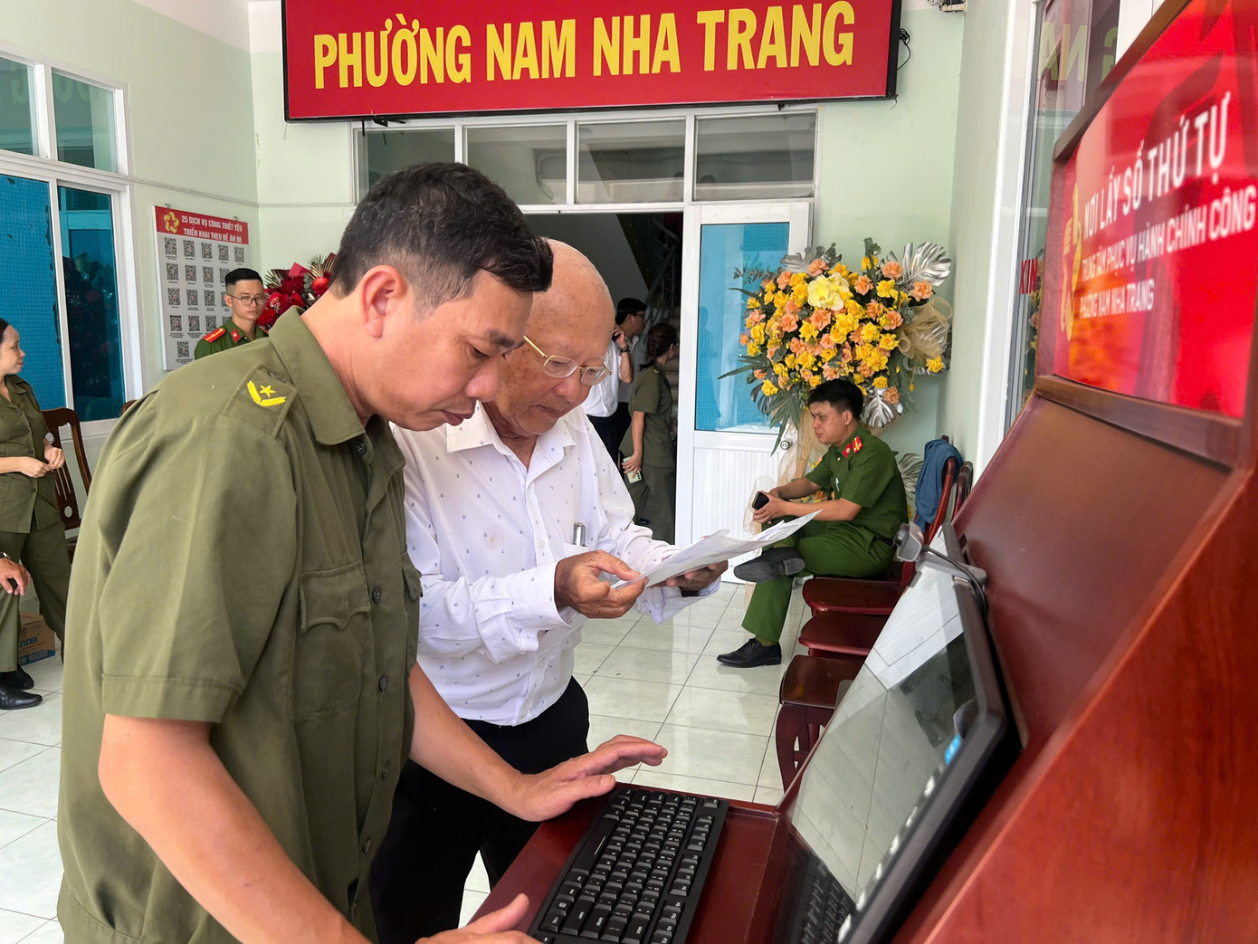 Cán bộ UBND phường Nam Nha Trang hướng dẫn cho người dân lấy số thứ tự.