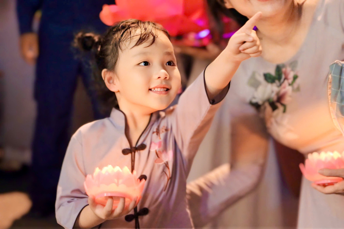 Một em bé theo gia đình tham gia lễ thả hoa đăng.