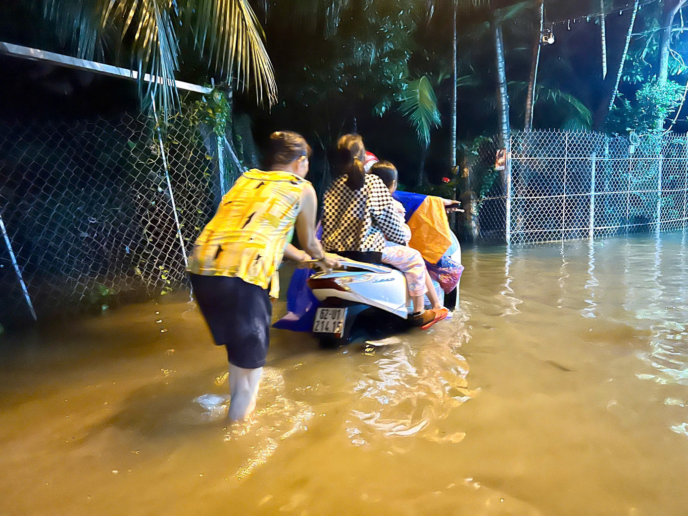 Đường ngập sâu, xe chết máy. Chị Trần Thị Ngọc Nữ ( trú phường Ngọc Hiệp, TP Nha Trang) phải nhờ người đẩy xe giúp.