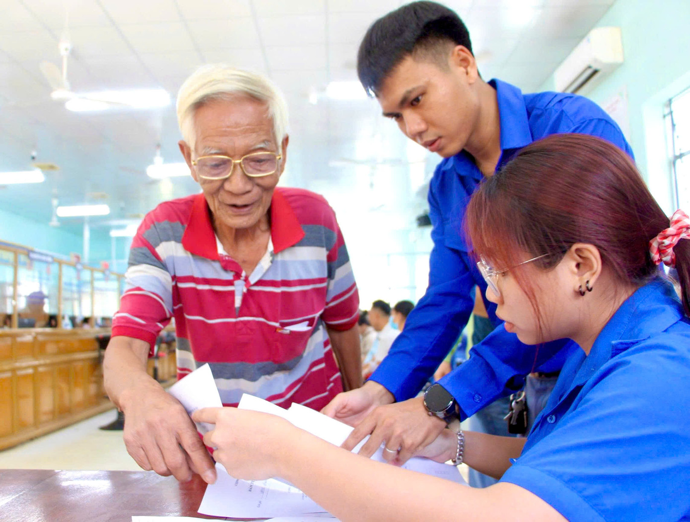 Nhiều người dân lớn tuổi khác ở Khánh Hòa cũng đang gặp khó khăn trong việc tiếp cận thủ tục hành chính. Trong ảnh: Ông Phạm Văn Lắng (72 tuổi, phường Cam Ranh, tỉnh Khánh Hòa) được các thanh niên tình nguyện phường Cam Ranh hướng dẫn làm hồ sơ đăng ký đất đai, tài sản gắn liền với đất.