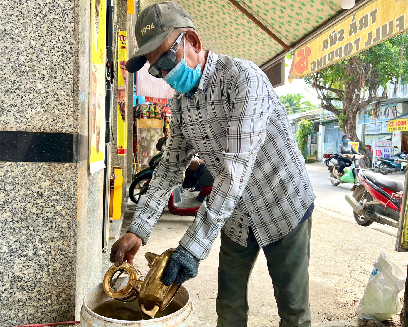 Trước khi thực hiện đánh bóng, người thợ phải loại bỏ vết bẩn bám trên lư đồng (ảnh trên) và ngâm lư đồng qua nước me hoặc khế chua để các vết gỉ sét nhả ra (ảnh dưới).