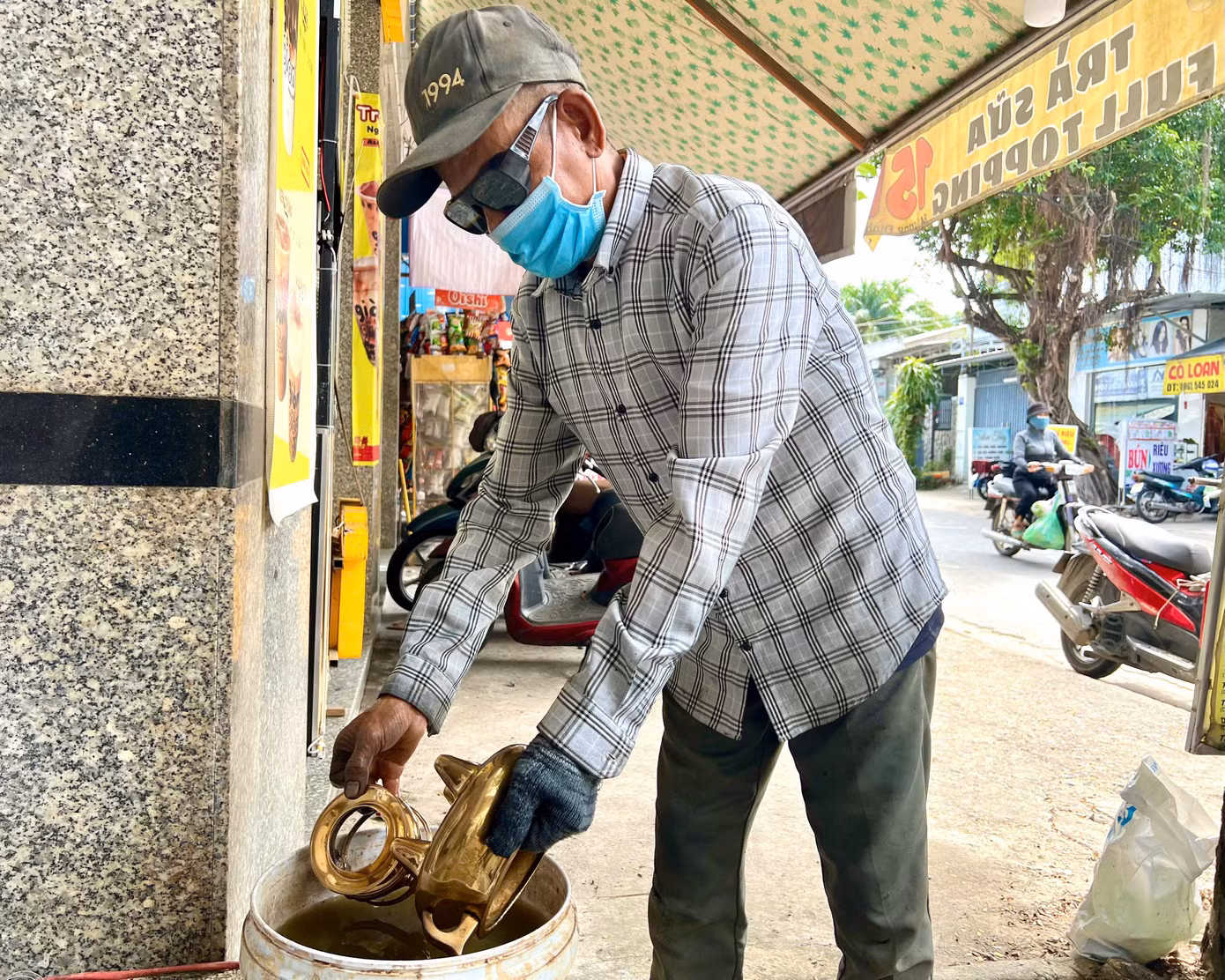 Trước khi thực hiện đánh bóng, người thợ phải loại bỏ vết bẩn bám trên lư đồng (ảnh trên) và ngâm lư đồng qua nước me hoặc khế chua để các vết gỉ sét nhả ra (ảnh dưới).