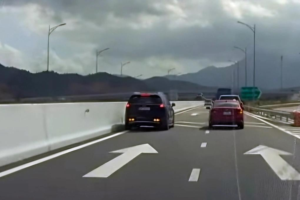 Xe ô tô 7 chỗ (màu đen, bên trái) chạy lùi trên cao tốc Nha Trang - Cam Lâm. Ảnh cắt từ clip