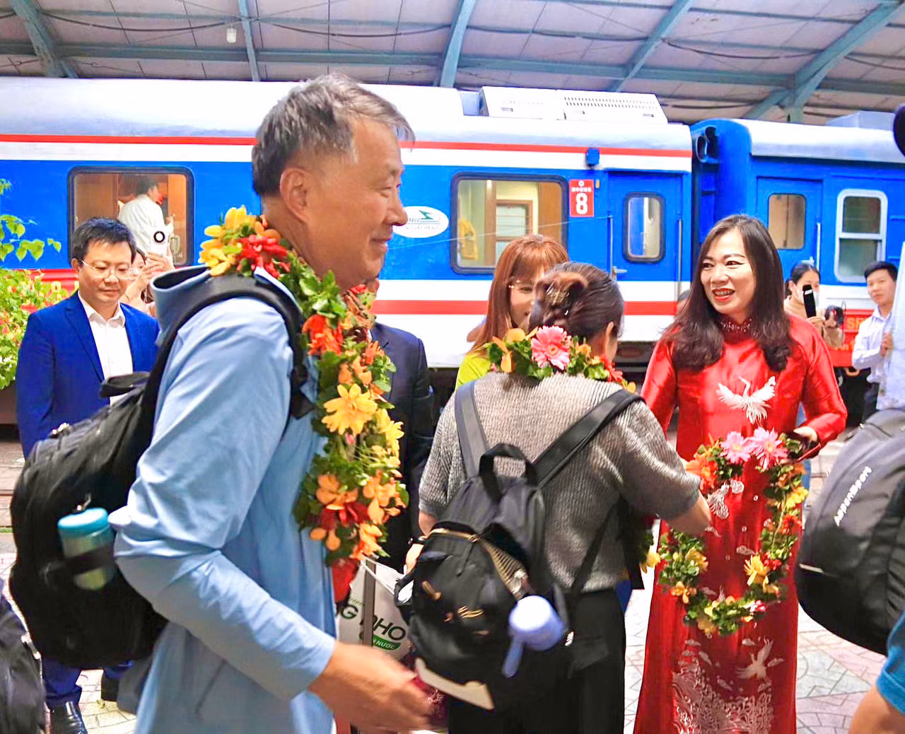 Lãnh đạo Sở Du lịch tỉnh Khánh Hòa tặng hoa và quà lưu niệm cho những vị khách đầu tiên bước xuống khi tới ga Nha Trang.