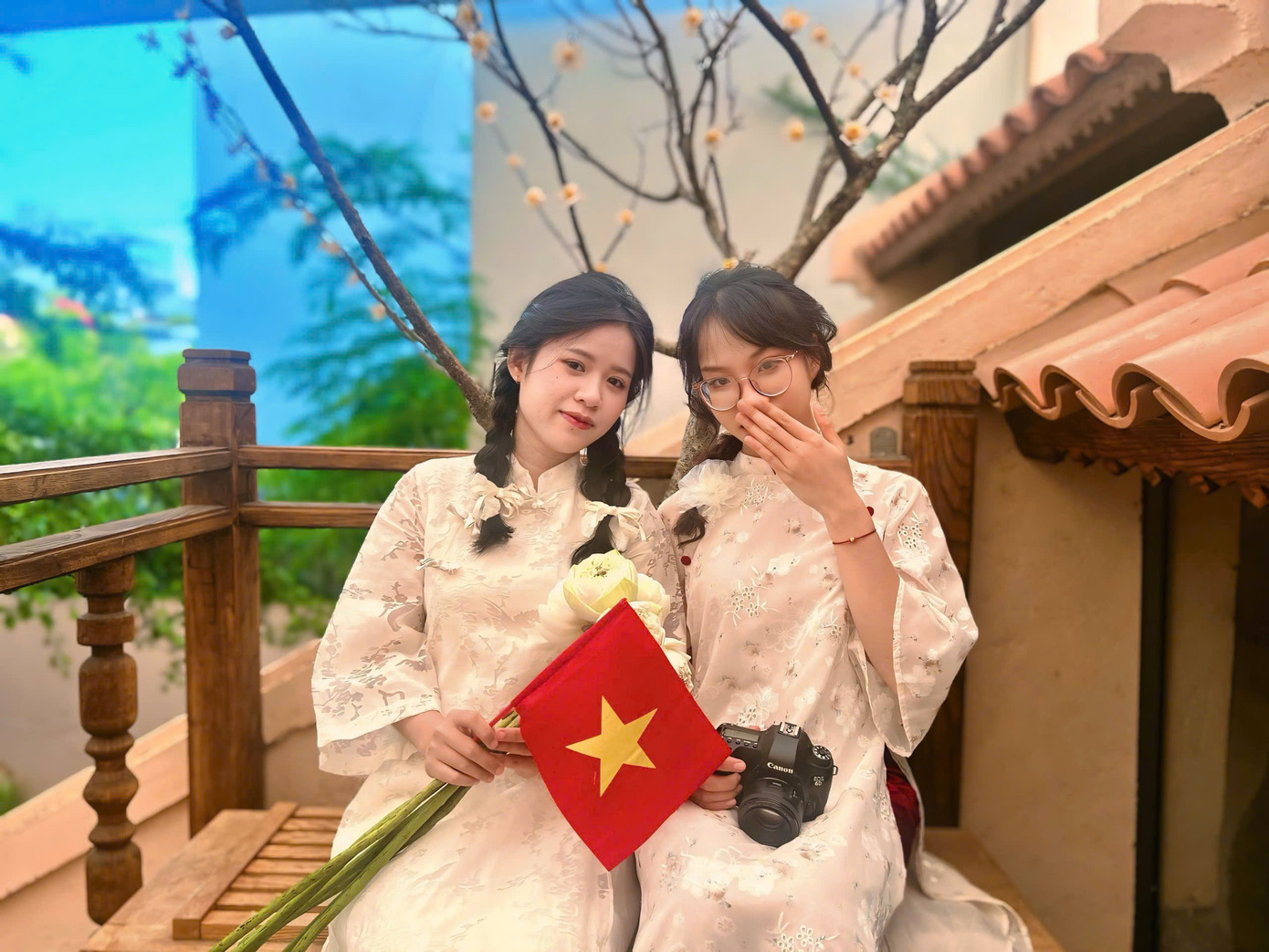 Bạn Nguyễn Ngọc Bảo Hân (bên phải) cùng với bạn mình mang theo cờ Tổ Quốc, đi từ huyện Diên Khánh đến TP. Nha Trang và tranh thủ ghé quán để chụp ảnh.