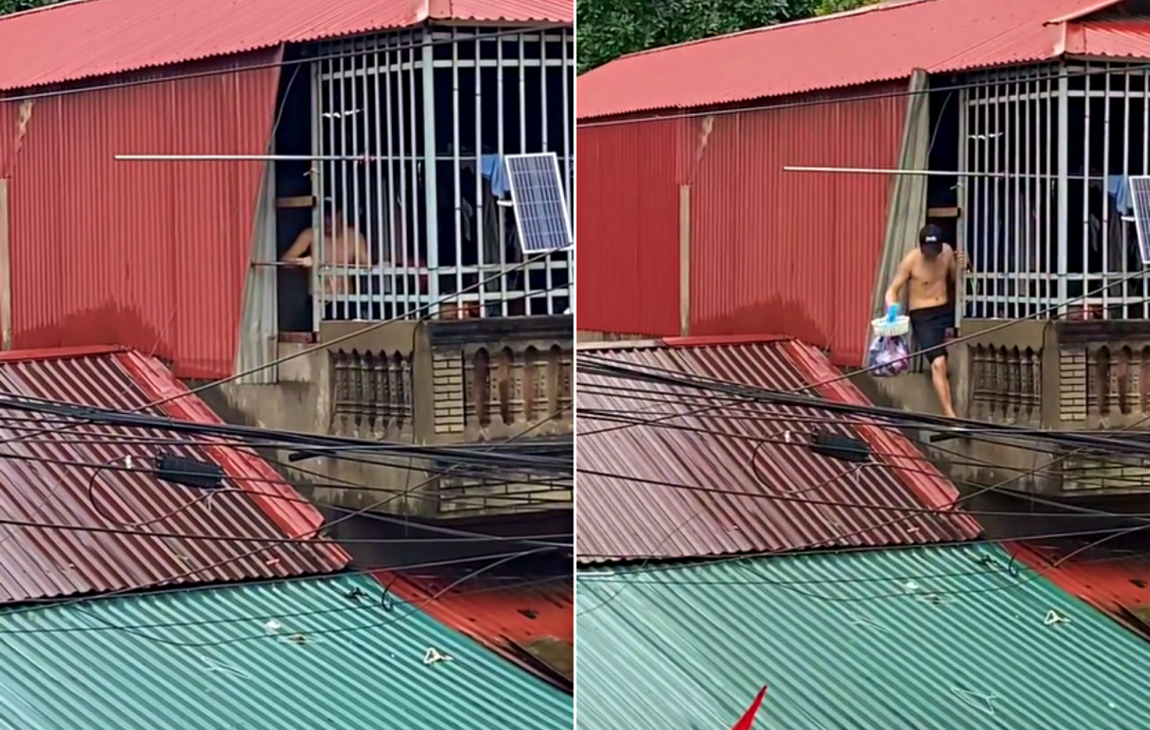 Người đàn ông tháo một góc vách nhà, trèo qua lỗ hổng. Ảnh: Cắt từ clip Người đàn ông tháo một góc vách nhà, trèo qua lỗ hổng. Ảnh: Cắt từ clip