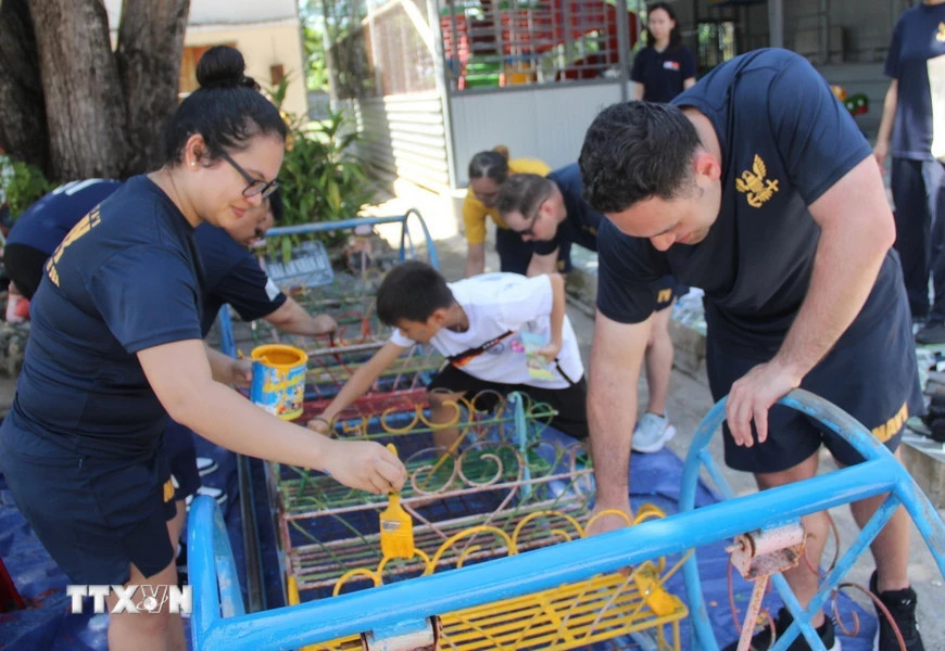 Đoàn thủy thủ Hải quân Hoa Kỳ sơn lại các thiết bị ở khu vui chơi trung tâm Mái Ấm Nhân Ái (xã Cam Phước Đông, thành phố Cam Ranh) trong chuyến thăm xã giao tỉnh Khánh Hòa (2024). (Ảnh: Phan Sáu/TTXVN)