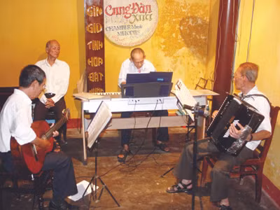 Ban nhạc U90 rộn ràng tiếng nhạc giữa phố Hội (cụ Quảng chơi piano, cụ Hao chơi phong cầm, bác Châu chơi guitar). Ảnh: Nguyễn Huy 