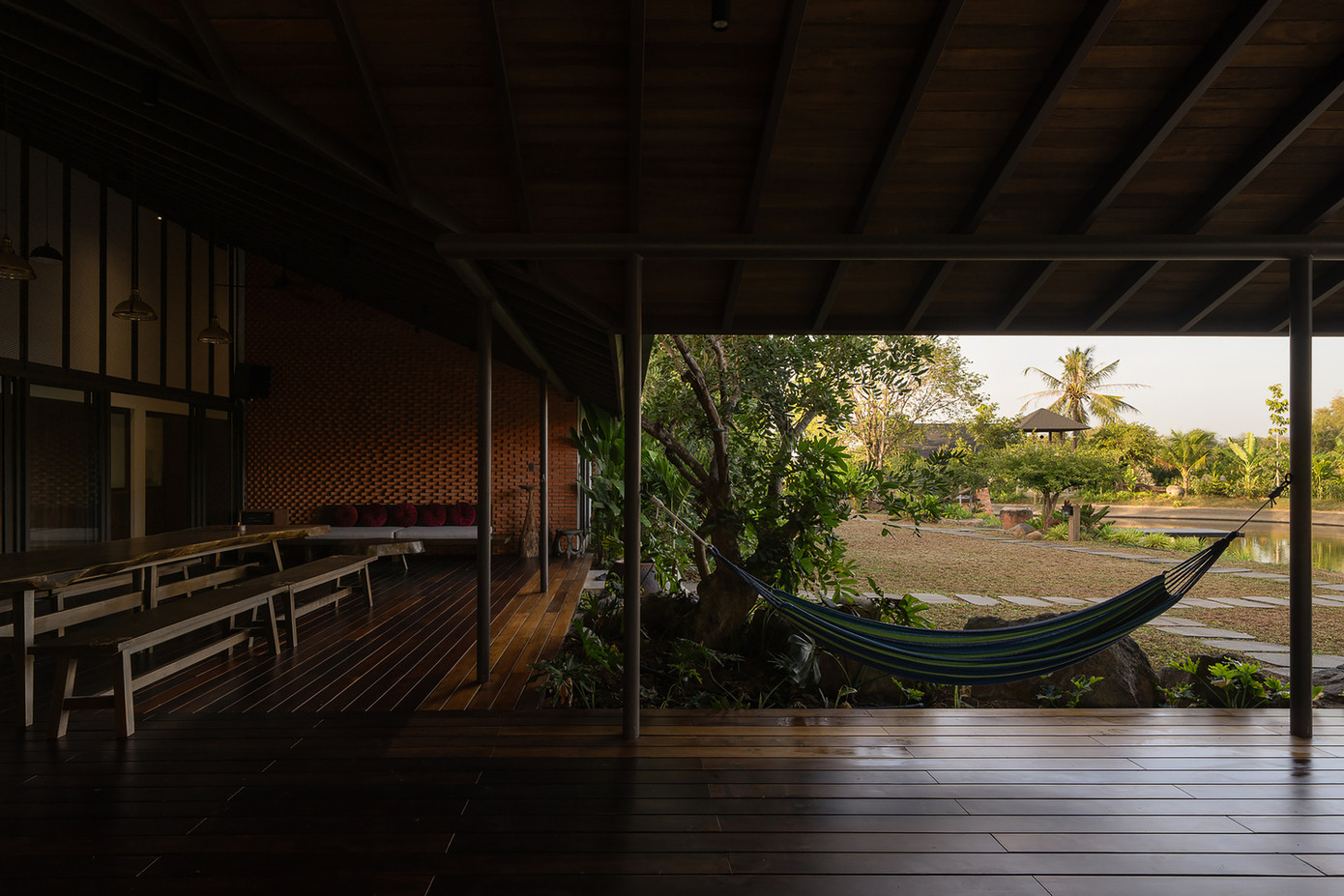 Dọc theo hiên nhà, gia chủ cho mắc võng và đặt một bàn trà đơn giản để ông bà thư giãn vào buổi chiều, lắng nghe tiếng chim hót và tận hưởng hương thơm của những cây ăn quả trong vườn.