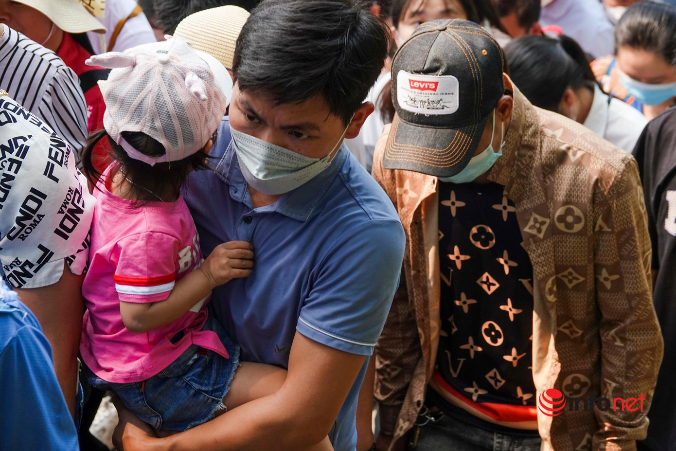 Một em nhỏ tỏ ra mệt mọt, được người lớn bồng bế đến Đền Hùng trong ngày nghỉ lễ đầu tiên.