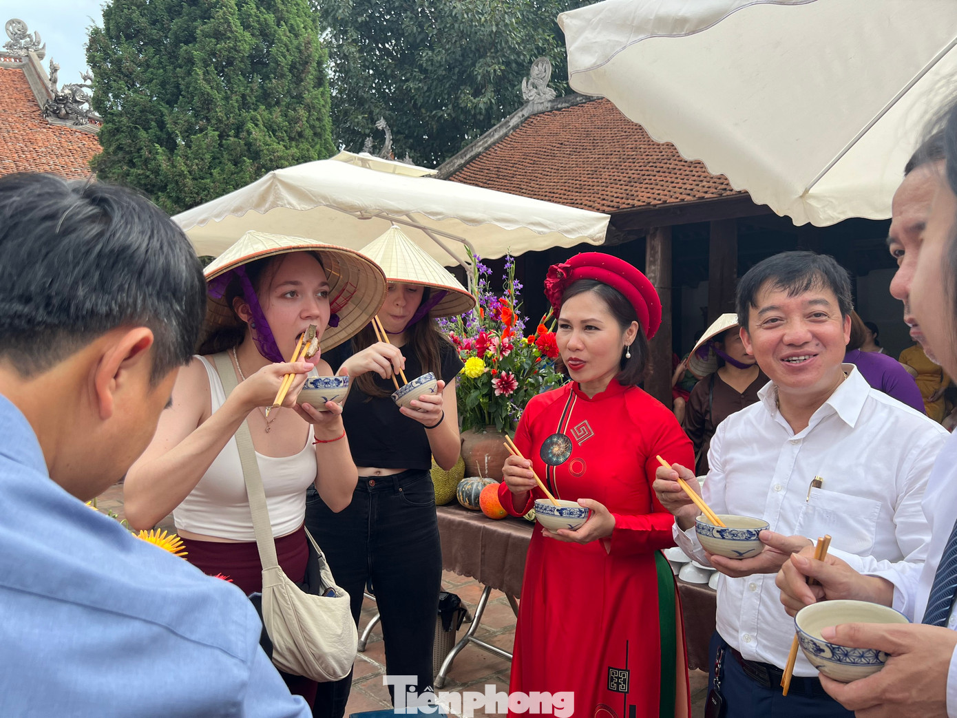 Khách du lịch quốc tế thích thú nếm thử bánh chưng, nem rán trong mâm cỗ cổ truyền của người dân Đường Lâm.