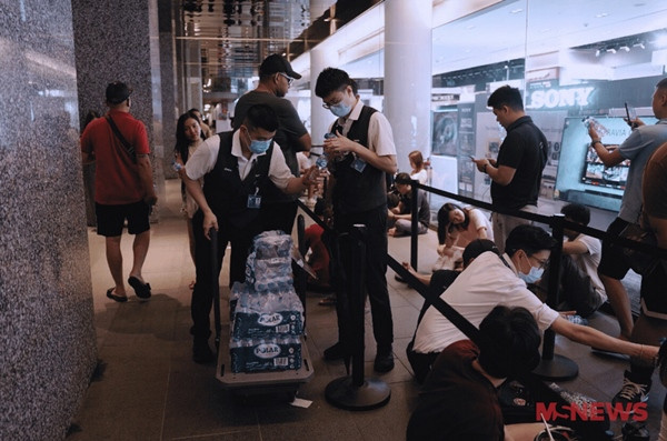Nhân viên cửa hàng đưa nước cho các fan xếp hàng từ hôm qua. Nhân viên cửa hàng đưa nước cho các fan xếp hàng từ hôm qua.