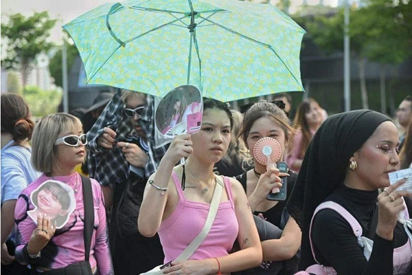 Các fan mặc trang phục màu đen và hồng đứng xếp hàng dưới nắng nóng từ buổi chiều để vào sân vận động, dù đến tối BLACKPINK mới biểu diễn. Ảnh: Desmond Wee.