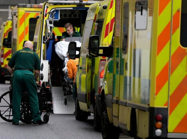 Nhân viên xe cấp cứu đang giúp bệnh nhân ngồi xe lăn lên xe bên ngoài Bệnh viện Hoàng gia London (Anh). Ảnh minh họa: AP. Nhân viên xe cấp cứu đang giúp bệnh nhân ngồi xe lăn lên xe bên ngoài Bệnh viện Hoàng gia London (Anh). Ảnh minh họa: AP.