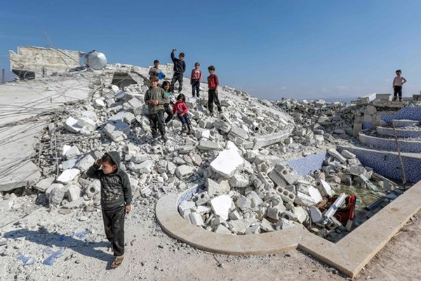 Trẻ em chơi loanh quanh trên các đồng gạch vụn của các tòa nhà bị sập do động đất. Ảnh: AFP via Getty.