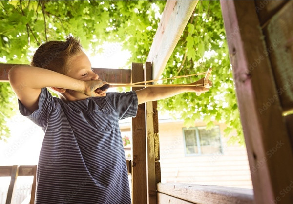 Cậu anh trai dùng ná cao su bắn về phía kẻ lạ mặt. Ảnh minh họa: AdobeStock. Cậu anh trai dùng ná cao su bắn về phía kẻ lạ mặt. Ảnh minh họa: AdobeStock.