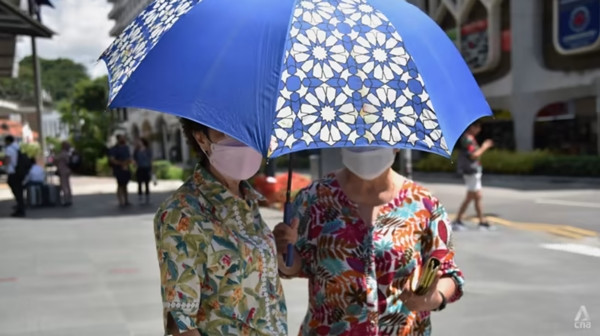 Hai người che chung ô dưới nắng nóng ở Singapore. Ảnh: Syamil Sapari/ CNA. Hai người che chung ô dưới nắng nóng ở Singapore. Ảnh: Syamil Sapari/ CNA.