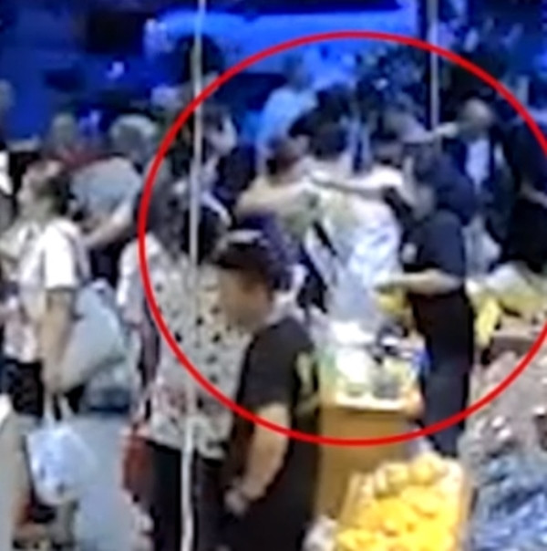 Tình huống do camera quan sát ghi lại, khi người bán hàng làm rơi quả sầu riêng trúng mặt bé gái. Ảnh: Weibo.