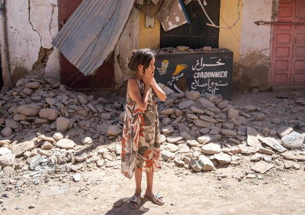 Một bé gái ở thị trấn Amizmiz đứng nhìn những đống đổ nát do động đất ở Ma-rốc. Ảnh: Mosa'ab Elshamy/ AP.