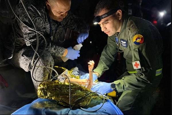 Đội cứu hộ giúp đỡ em út trong nhóm 4 trẻ. Ảnh: Colombian Air Force/ AFP - Getty.