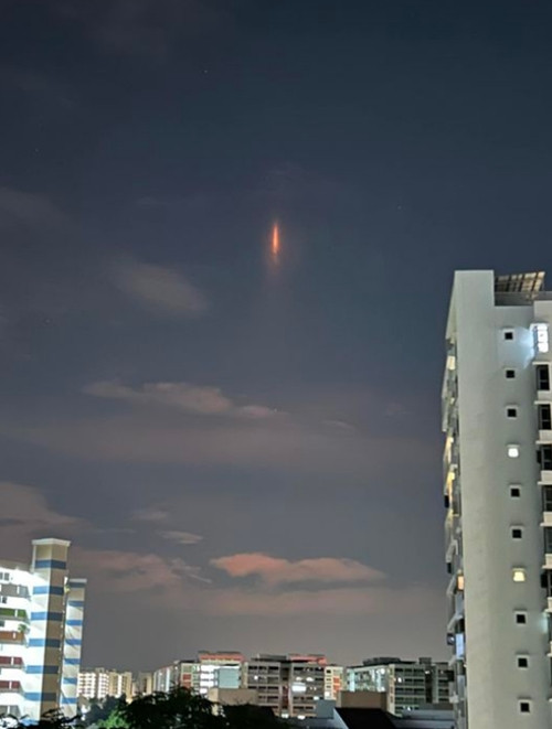 Vệt ánh sáng đỏ thẳng đứng trên bầu trời. Ảnh: Alice Ng. Vệt ánh sáng đỏ thẳng đứng trên bầu trời. Ảnh: Alice Ng.