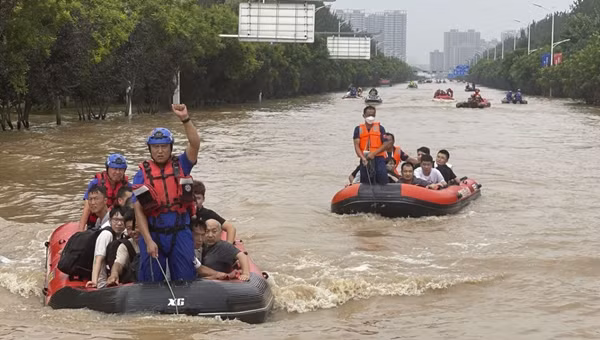 Người dân được đưa đi sơ bán bằng thuyền cao su giữa nước ngập ở Hà Bắc (Trung Quốc). Ảnh: AP.