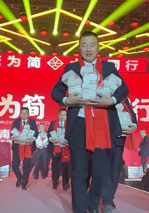 Nhân viên bê tiền trên sân khấu xuống. Ảnh: Weibo/ Dahe Daily. Nhân viên bê tiền trên sân khấu xuống. Ảnh: Weibo/ Dahe Daily.