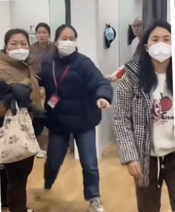 Một bà mẹ (bên phải của ảnh) lao tới giật điện thoại của Kira. Ảnh: Weibo.
