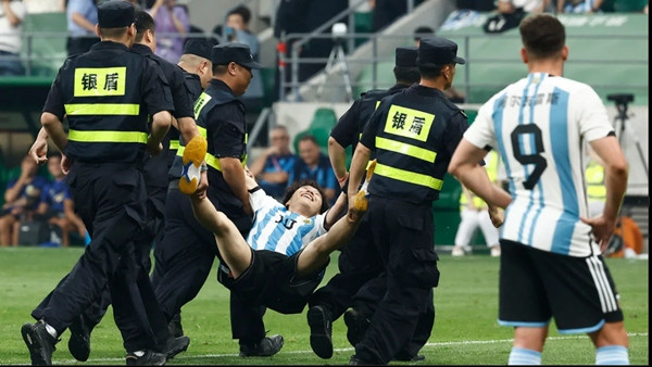 Di bị đưa ra khỏi sân. Ảnh: Thomas Peters on Reuters via CNN.