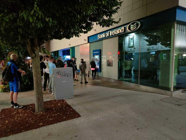 Nhiều người xếp hàng trước một cây ATM ở thành phố Limerick (Ireland) để "rút tiền miễn phí". Ảnh: Limerick Live. Nhiều người xếp hàng trước một cây ATM ở thành phố Limerick (Ireland) để "rút tiền miễn phí". Ảnh: Limerick Live.