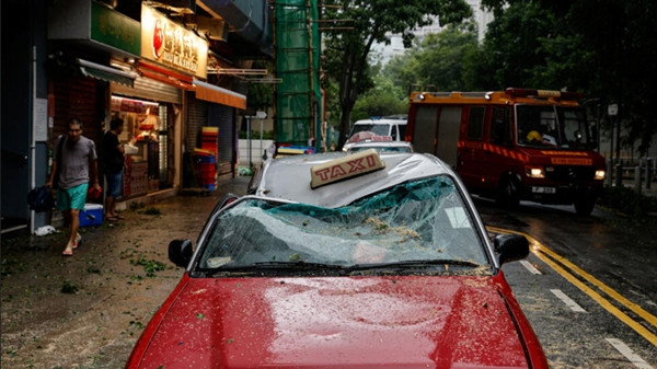 Một chiếc xe taxi ở Hong Kong (Trung Quốc) bị hư hại do cây đổ vào hôm 2/9 trong bão Saola. Ảnh: Tyrone Siu/ Reuters.