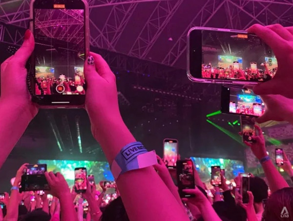 Một biển điện thoại khiến nhiều khán giả không thể xem được các cô gái biểu diễn. Ảnh: Grace Yeoh/ CNA.