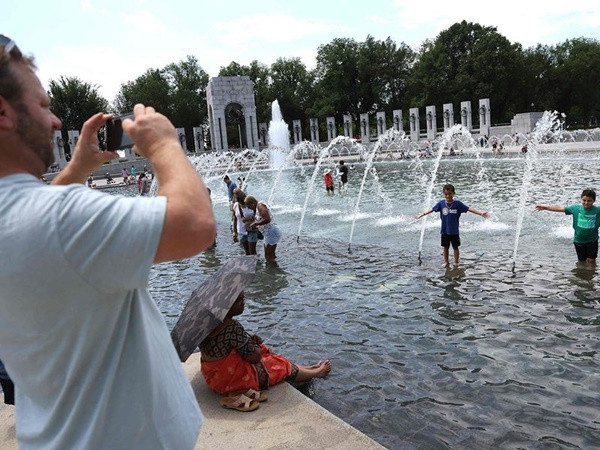 Người nào cũng cố đến chỗ những vòi phun nước cho mát hơn - ảnh chụp hôm 3/7 ở Washington D.C (Mỹ). Ảnh: AFP.