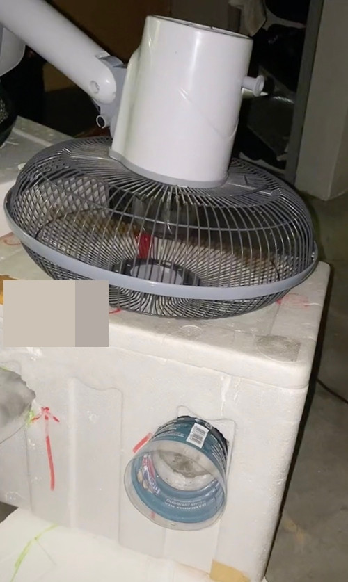 Kê cái quạt úp "mặt" vào nắp thùng xốp (đã khoét lỗ), tạo thành "máy điều hòa" đơn giản. Ảnh: Daniel. Kê cái quạt úp "mặt" vào nắp thùng xốp (đã khoét lỗ), tạo thành "máy điều hòa" đơn giản. Ảnh: Daniel.