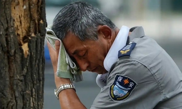 Một bác bảo vệ lau mồ hôi giữa cái nóng tại Bắc Kinh (Trung Quốc). Ảnh: Andy Wong/ AP. Một bác bảo vệ lau mồ hôi giữa cái nóng tại Bắc Kinh (Trung Quốc). Ảnh: Andy Wong/ AP.